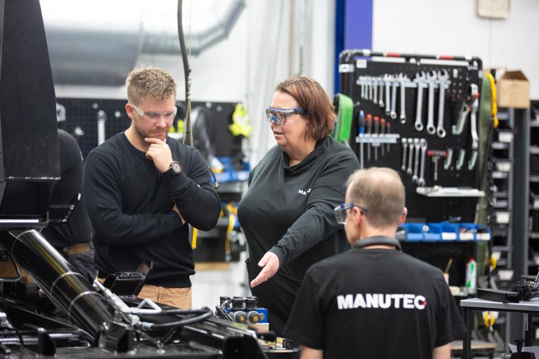 Neuvottelu tehtaalla työpisteen äärellä.